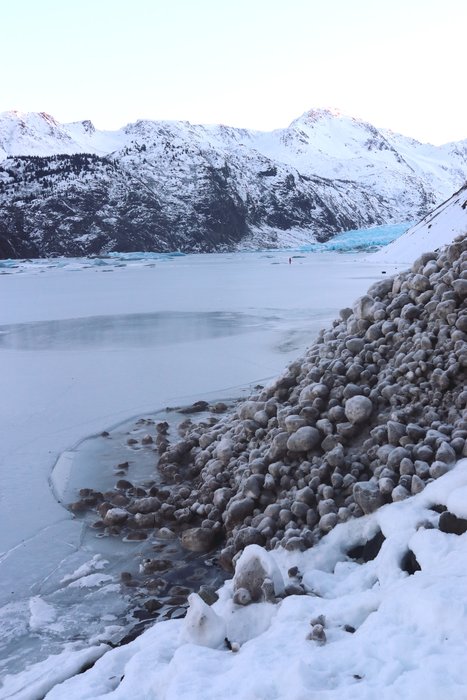A period of heavy rain allowed Grewingk Lake to freeze into a smooth sheet, but it also triggered avalanches on the surrounding slopes. This one made it to the water, breaking the weak ice there.