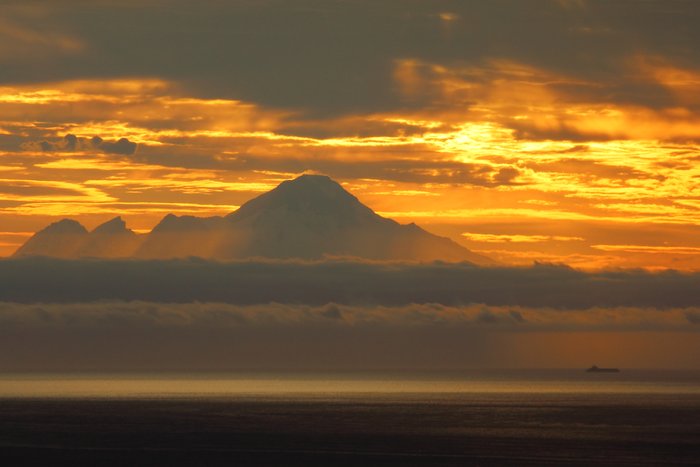 A small cargo vessel - perhaps a oil tanker - makes its way up Cook Inlet.