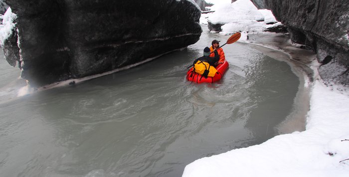 Hig paddles upstream carrying the Greg, our documentarian, across river winding between ice-boulders.
