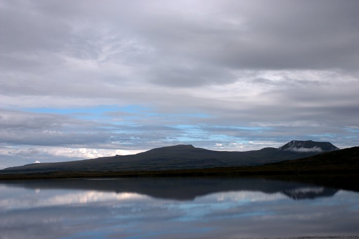 Northern hills reflected in the glassy surface of Frying Pan Lake.
