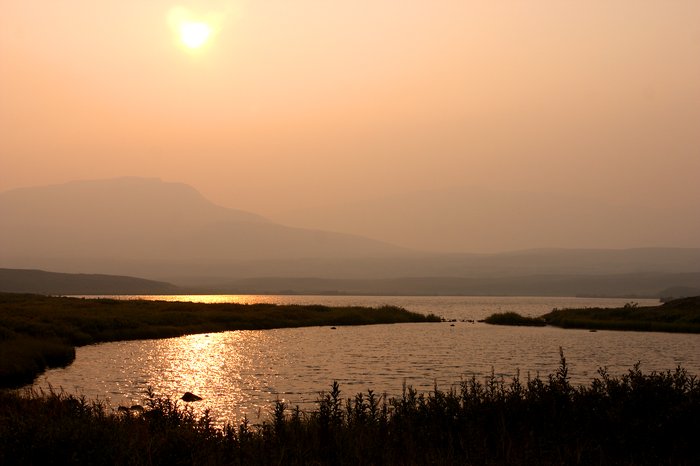 The sun sets in a pink haze of forest fire smoke. Looking west towards Groundhog Mountain.