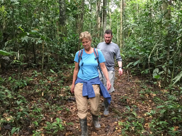 Niki and Scott hiking along a narrow rainforest trail.