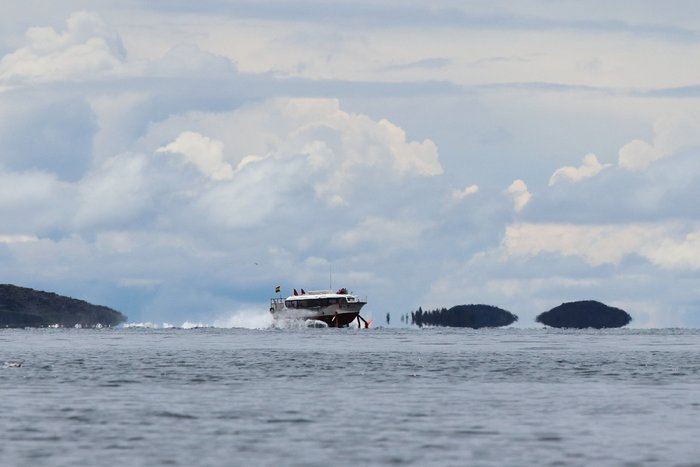 A hydrofoil tourist boat passes between Isla del Sol and Isla de la Luna on Lake Titicaca.