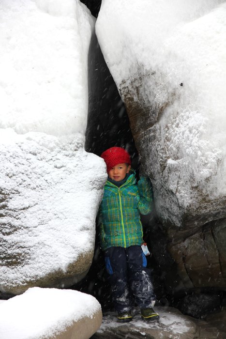In a notch in a boulder, looking out at the snow
