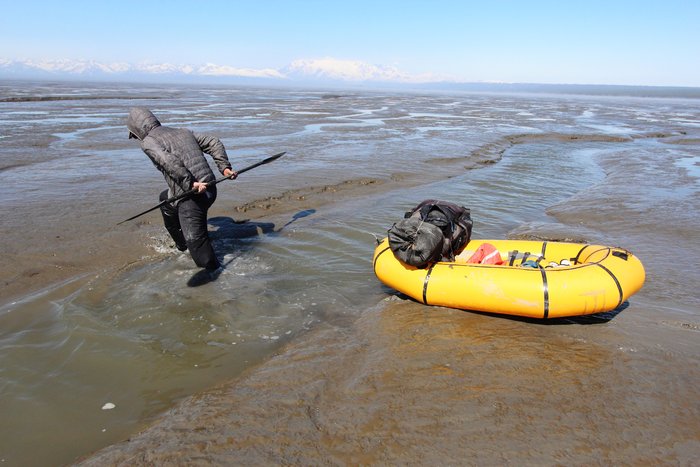 Hig pulling the raft across a slough in the Trading Bay mudflats