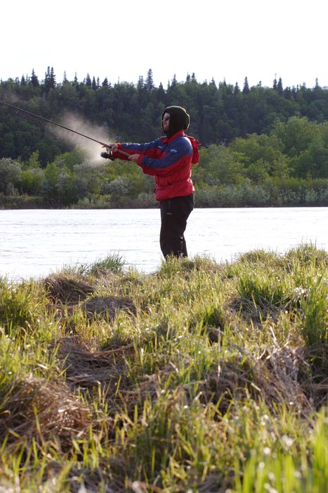 Spray shooting off Tom's fishing line as he fishes at the confluence of the Mulchatna and Nushagak Rivers. 