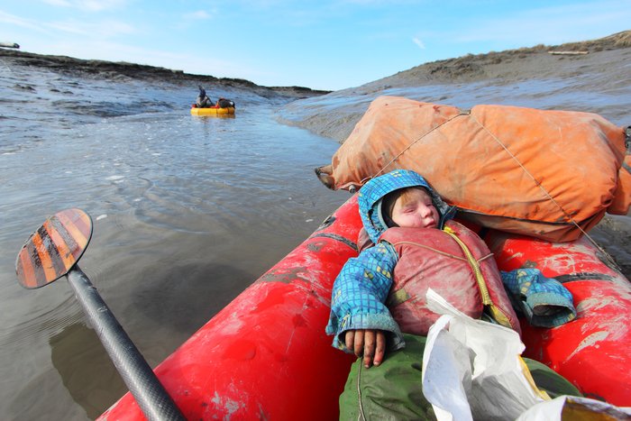 Lituya sleeps in the raft as it travels down a slough on the Susitna Flats
