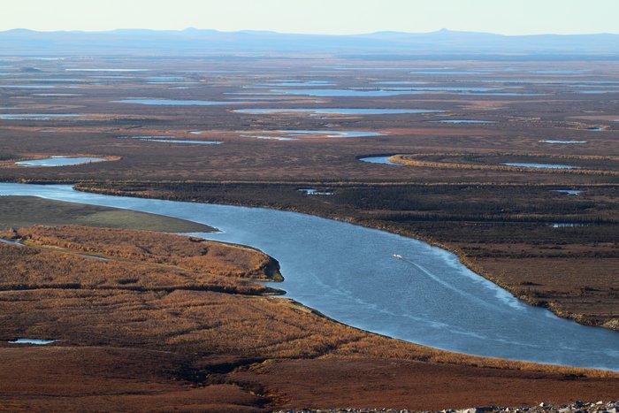 A distant boat speeds up the Noatak River