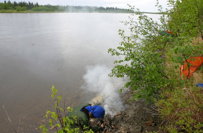 Hig starting a smoky fire on a small muddy beach along the Nushagak River. 