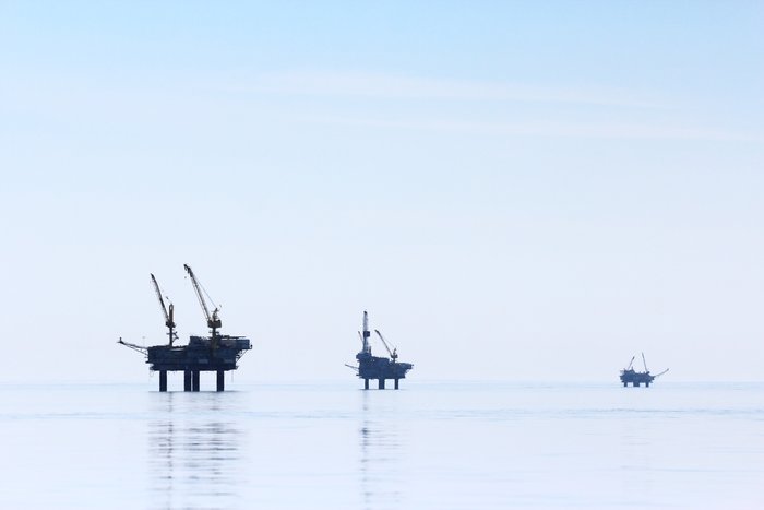Calm seas surround the oil rigs as we paddle between Tyonek and Granite Point