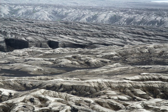 The 2008 eruption of Okmok initiated extensive erosion of lake deposits on the caldera floor, forming badlands.