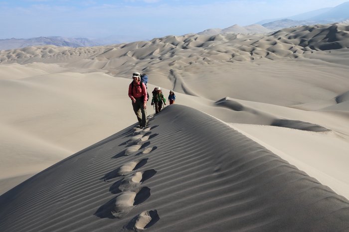 Hiking across the giant dunes of the Peruvian desert.