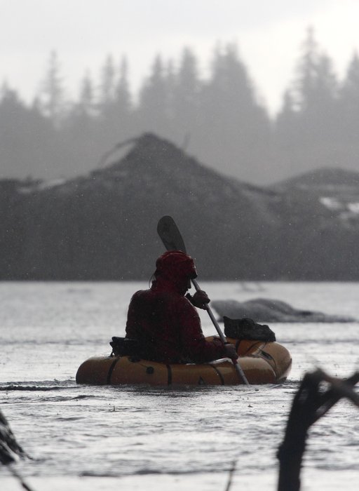 Visiting photographer Carl Donohue paddles his packraft in heavy rain.