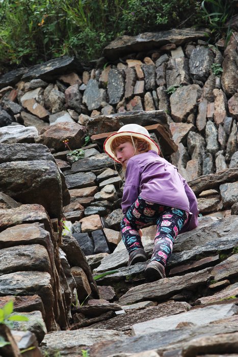Lituya climbs a set of stairs amongst Inca terraces at Choquequirao, Peru.
