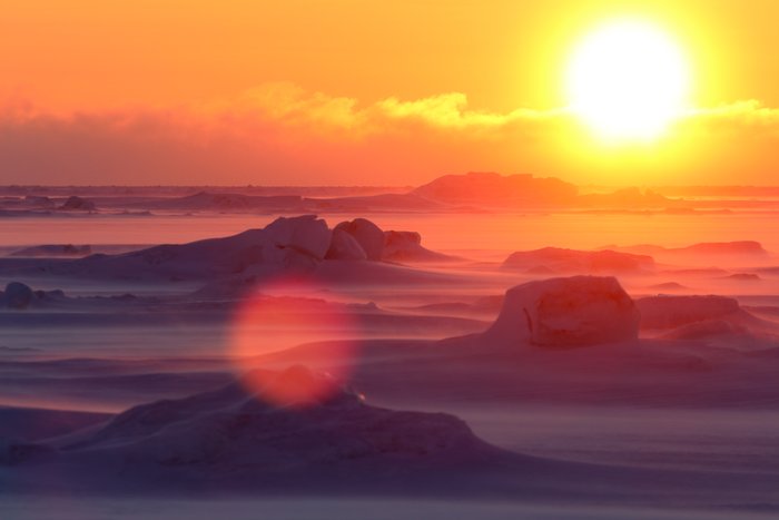 Ice fog drifts off distant open water in strong winds.  The temperature is around zero F.