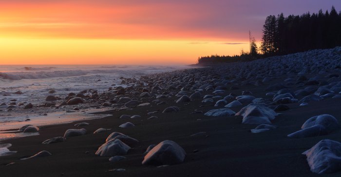 The sun sets on surf on this cobble beach on the coast of Malaspina Glacier