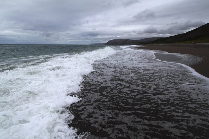 Waves break on a sandy beach south of Cape Lisburne