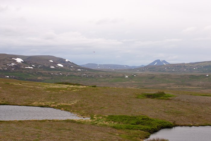Looking across the headwaters of Upper Talarik Creek to the mine site and Sharp Mountain. Helicopter flying overhead.